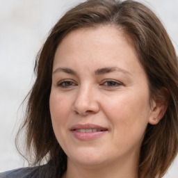 Joyful white adult female with long  brown hair and brown eyes