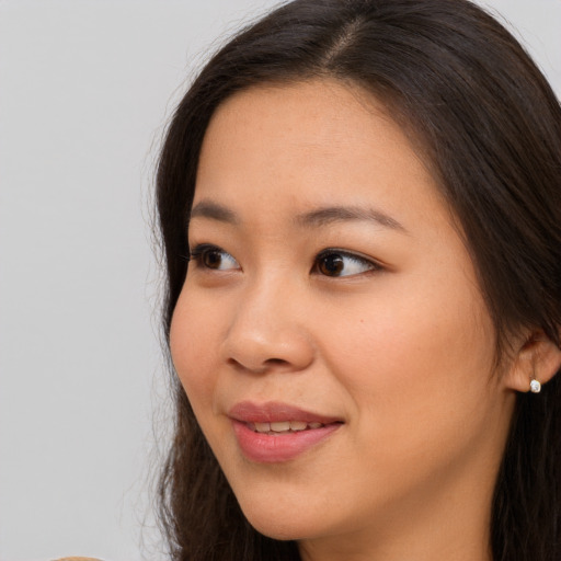 Joyful asian young-adult female with long  brown hair and brown eyes