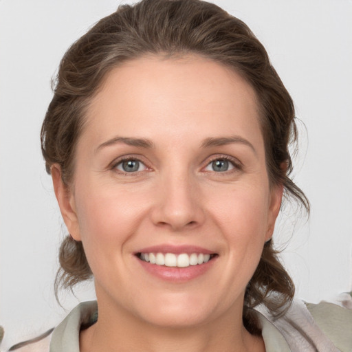 Joyful white young-adult female with medium  brown hair and grey eyes