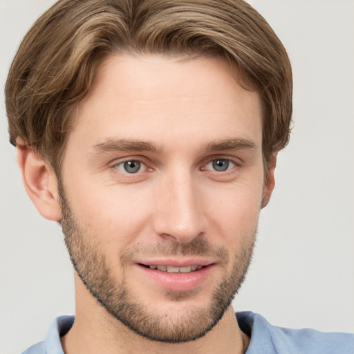 Joyful white young-adult male with short  brown hair and grey eyes