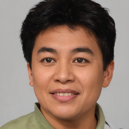 Joyful asian young-adult male with short  brown hair and brown eyes