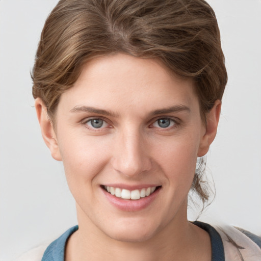 Joyful white young-adult female with short  brown hair and grey eyes