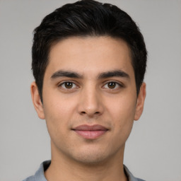 Joyful white young-adult male with short  black hair and brown eyes