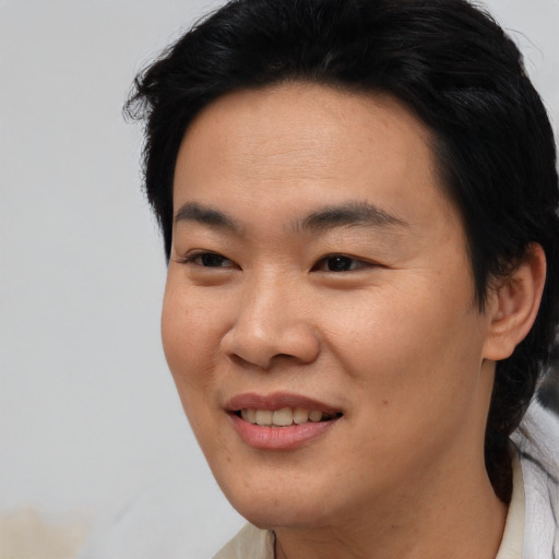 Joyful asian young-adult male with medium  black hair and brown eyes