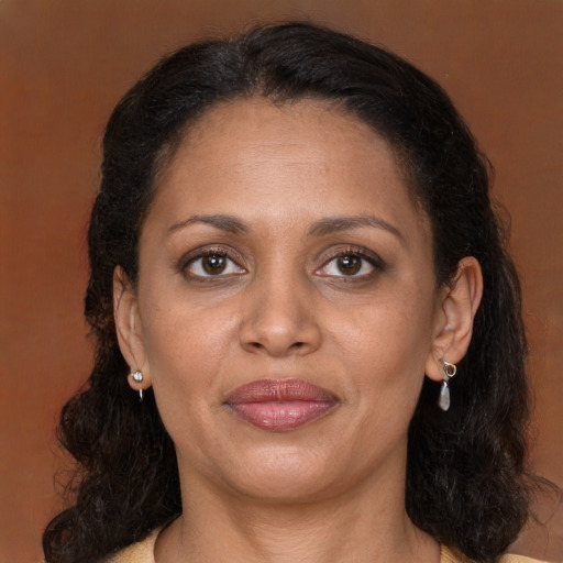 Joyful black adult female with long  brown hair and brown eyes