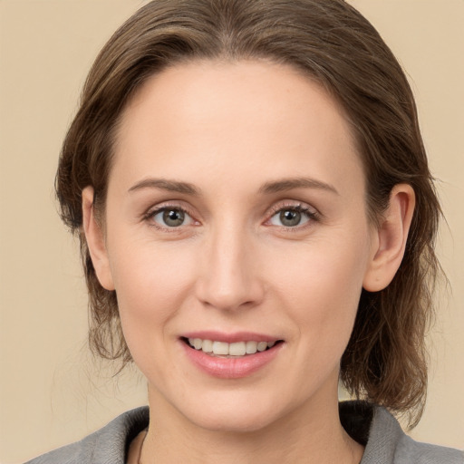 Joyful white young-adult female with medium  brown hair and grey eyes