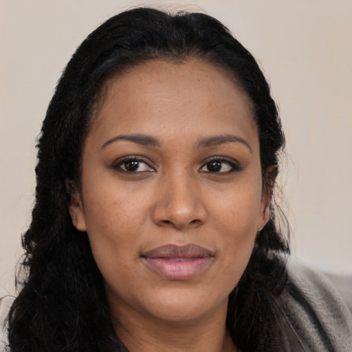 Joyful black young-adult female with long  black hair and brown eyes