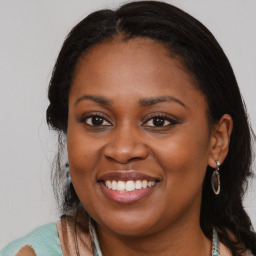 Joyful black young-adult female with long  brown hair and brown eyes