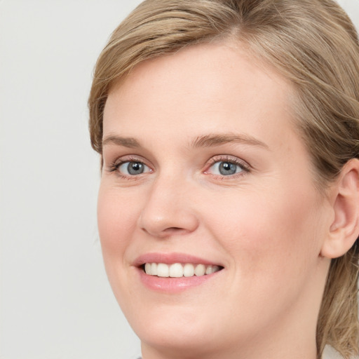 Joyful white young-adult female with long  brown hair and blue eyes