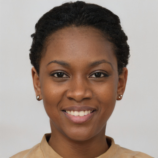 Joyful black young-adult female with short  black hair and brown eyes