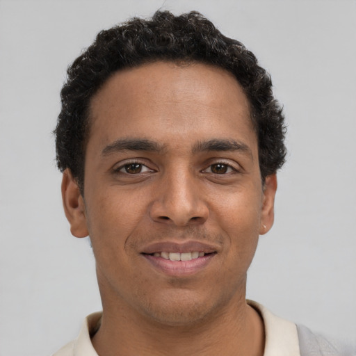 Joyful latino young-adult male with short  brown hair and brown eyes