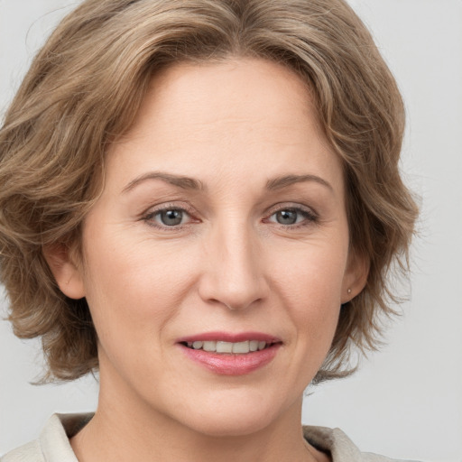 Joyful white adult female with medium  brown hair and grey eyes