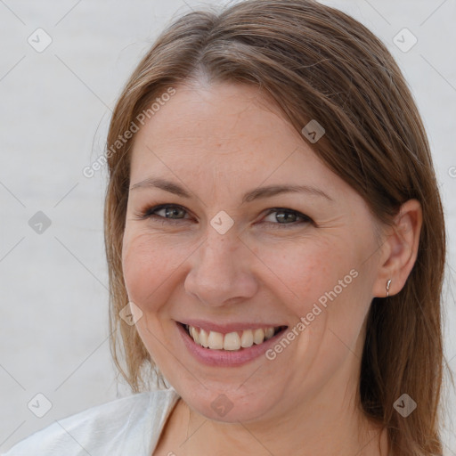 Joyful white adult female with medium  brown hair and grey eyes