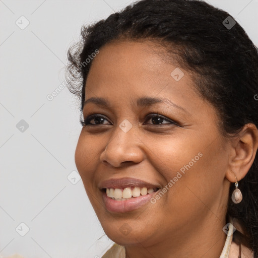 Joyful black young-adult female with long  brown hair and brown eyes