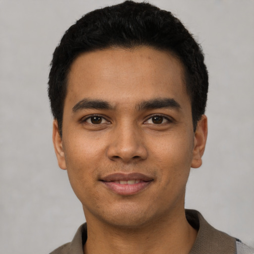 Joyful latino young-adult male with short  black hair and brown eyes