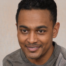 Joyful black young-adult male with short  black hair and brown eyes
