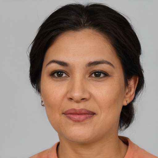 Joyful latino adult female with medium  brown hair and brown eyes