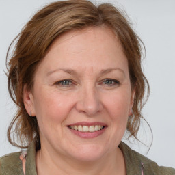 Joyful white adult female with medium  brown hair and blue eyes