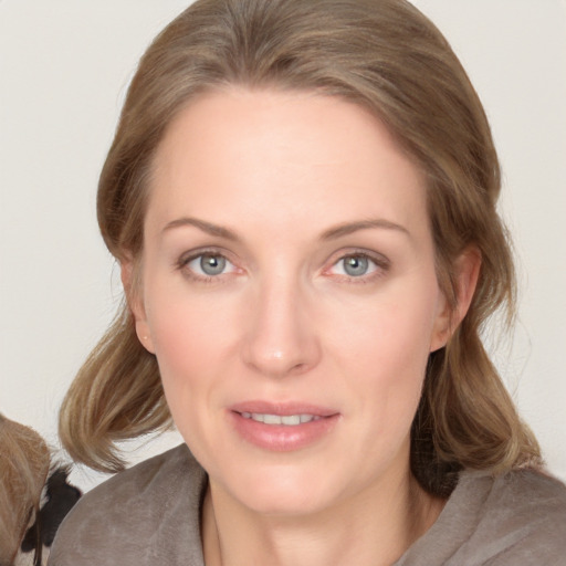 Joyful white adult female with medium  brown hair and blue eyes