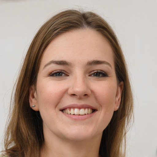 Joyful white young-adult female with long  brown hair and grey eyes