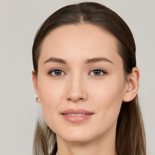 Joyful white young-adult female with long  brown hair and brown eyes