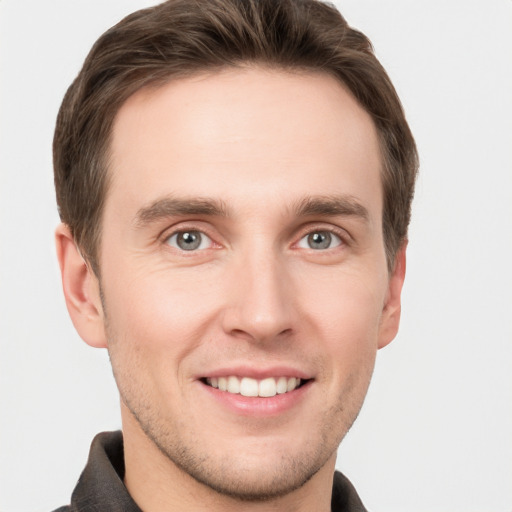 Joyful white young-adult male with short  brown hair and grey eyes