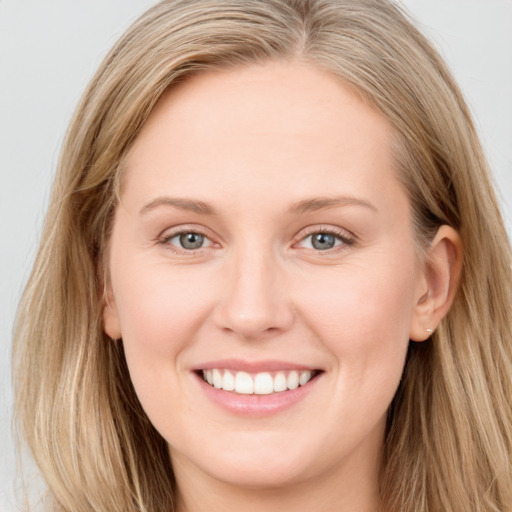 Joyful white young-adult female with long  brown hair and blue eyes