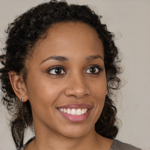 Joyful black young-adult female with medium  brown hair and brown eyes