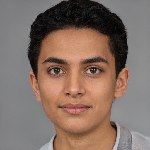 Joyful latino young-adult male with short  brown hair and brown eyes