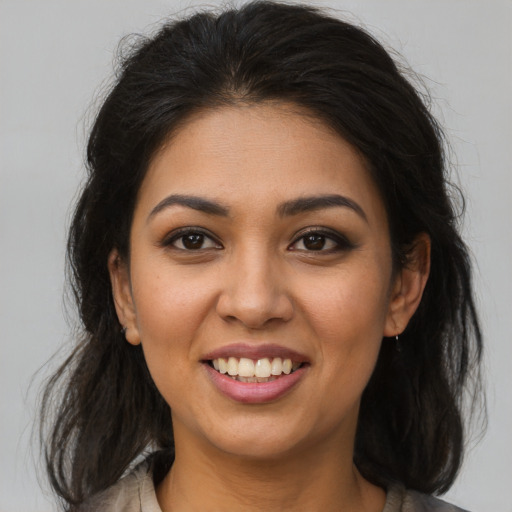 Joyful latino young-adult female with medium  brown hair and brown eyes