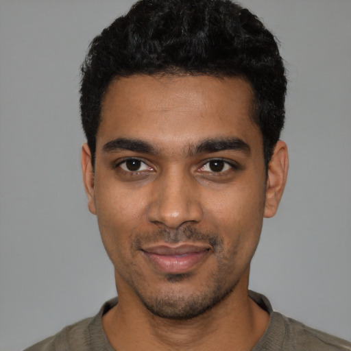 Joyful black young-adult male with short  black hair and brown eyes