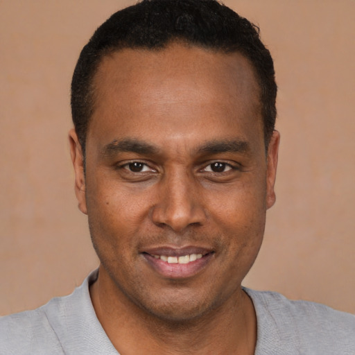 Joyful latino young-adult male with short  brown hair and brown eyes