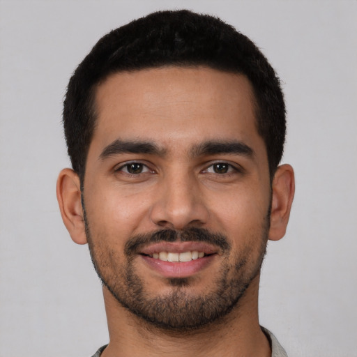 Joyful latino young-adult male with short  black hair and brown eyes
