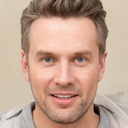 Joyful white adult male with short  brown hair and grey eyes