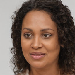 Joyful black adult female with long  brown hair and brown eyes