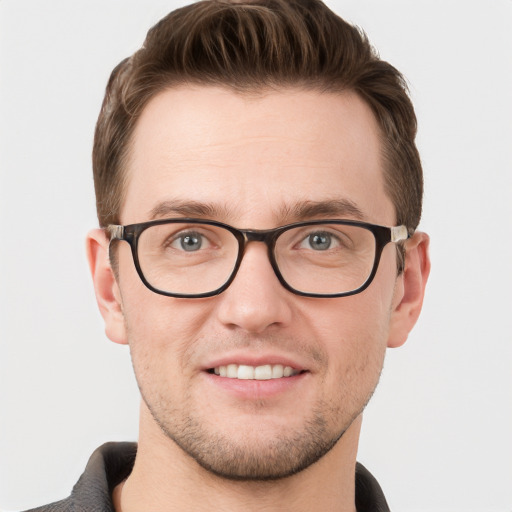 Joyful white young-adult male with short  brown hair and grey eyes