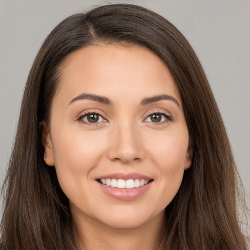 Joyful white young-adult female with long  brown hair and brown eyes