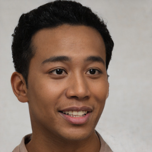 Joyful latino young-adult male with short  black hair and brown eyes