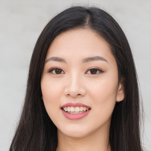 Joyful asian young-adult female with long  brown hair and brown eyes