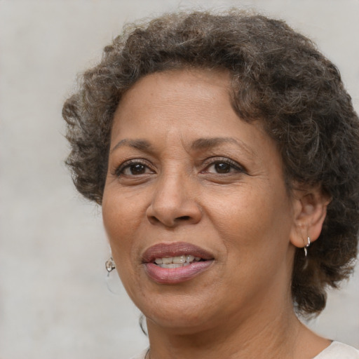 Joyful black adult female with medium  brown hair and brown eyes