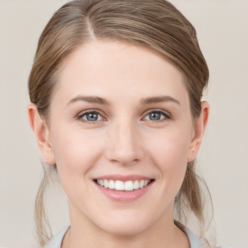 Joyful white young-adult female with medium  brown hair and grey eyes