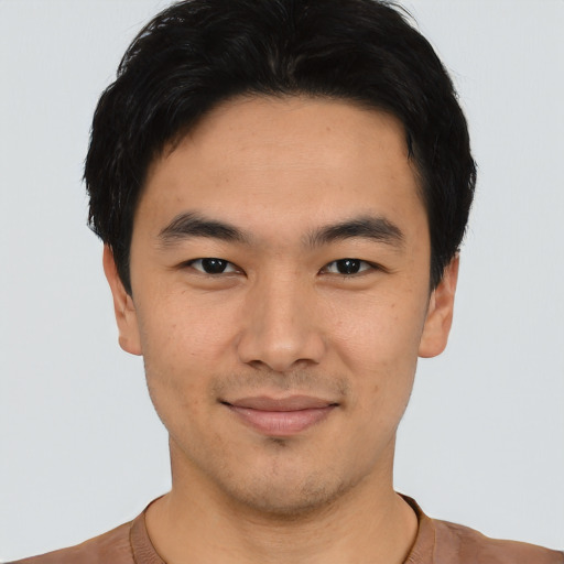 Joyful asian young-adult male with short  black hair and brown eyes
