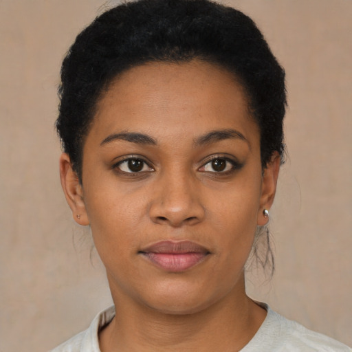Joyful black young-adult female with short  black hair and brown eyes