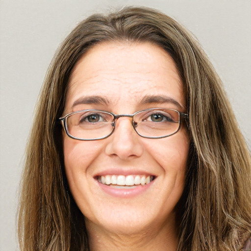 Joyful white adult female with long  brown hair and green eyes