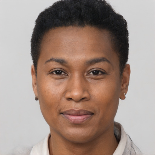 Joyful black young-adult female with short  black hair and brown eyes