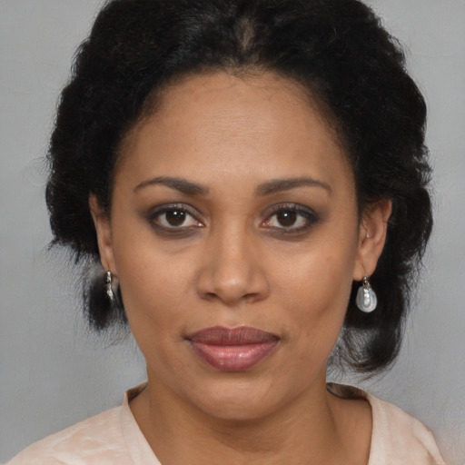 Joyful black adult female with medium  brown hair and brown eyes