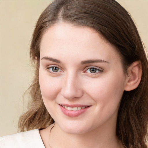 Joyful white young-adult female with long  brown hair and green eyes