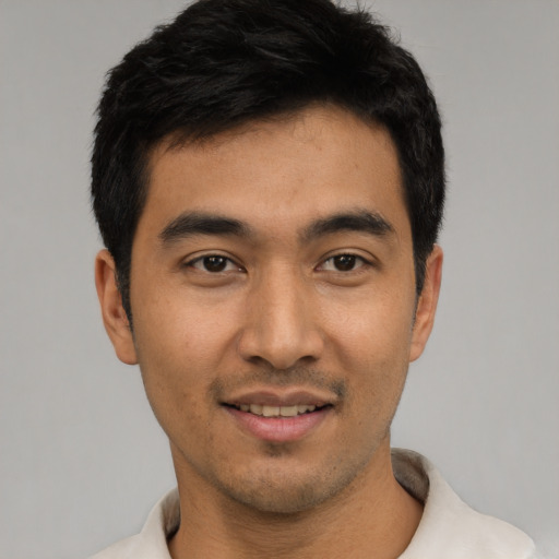Joyful latino young-adult male with short  black hair and brown eyes