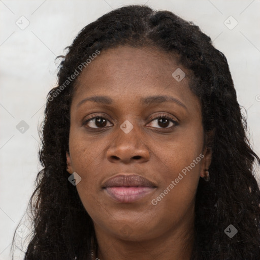 Joyful black young-adult female with long  brown hair and brown eyes