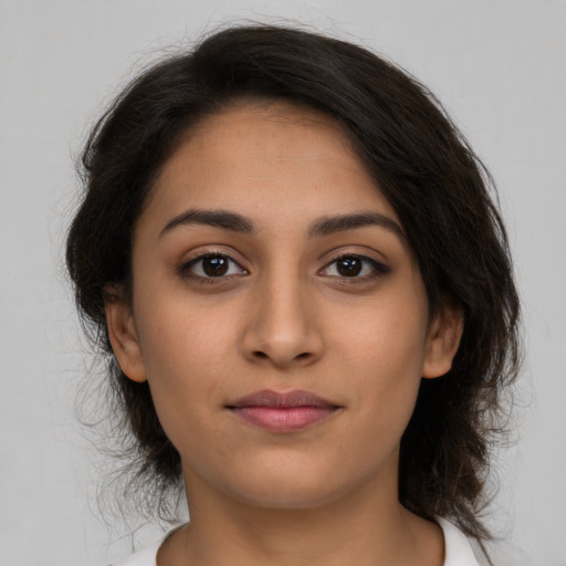 Joyful latino young-adult female with medium  brown hair and brown eyes